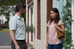 a man standing next to a woman in front of a building