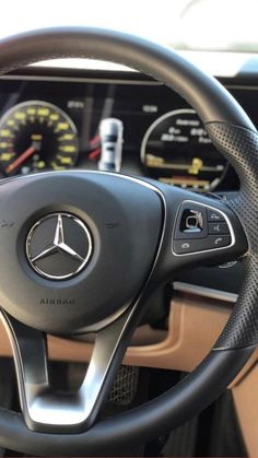 the steering wheel and dashboard of a mercedes benz benz - benz car, with gauges on