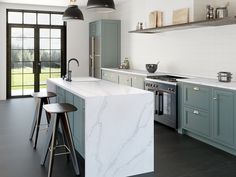 a kitchen with marble counter tops and blue cabinets