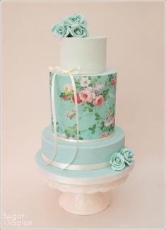 a three tiered cake decorated with flowers and ribbons