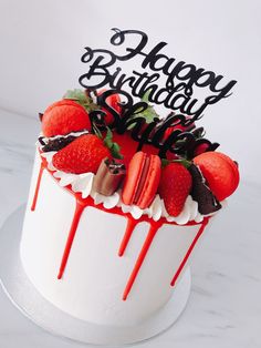 a birthday cake decorated with strawberries and chocolate