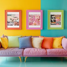 a living room filled with colorful pillows and pictures on the wall above it's couch