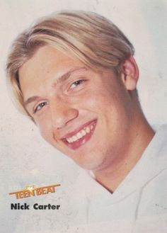 a young man with blonde hair smiling for the camera in front of a white background