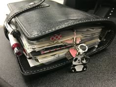 a wallet with a panda keychain hanging out of it's front pocket