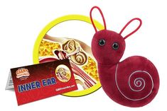 a red stuffed animal next to a yellow and white plate with an inner ear package