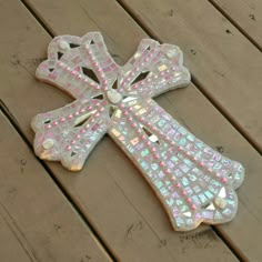 a decorative glass cross sitting on top of a wooden table