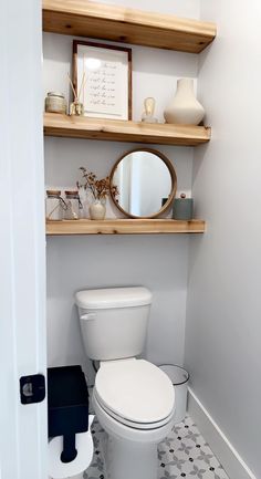 a white toilet sitting under a bathroom mirror