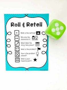 a green dice sitting on top of a piece of paper next to a roll and reel game