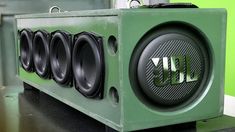 an array of speakers sitting on top of a green box in front of a wall