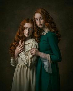 two red headed women in green dresses posing for a photo together, one is holding the other's shoulder