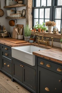 a kitchen with wooden counter tops and gray painted cabinets, an old fashioned farmhouse sink sits in front of a window