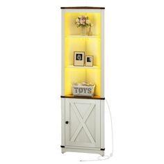 a tall white cabinet with yellow lights on it's sides and pictures above the doors