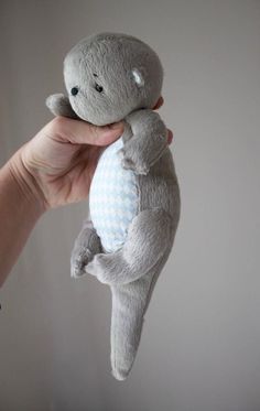 a person holding a stuffed animal in their left hand and the other hand on top of it