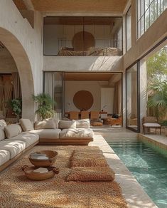 a living room filled with lots of furniture next to a swimming pool in a house