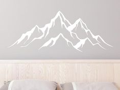 a white mountain wall decal above a bed