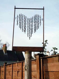 a tree with chains hanging from it's branches in front of a wooden fence