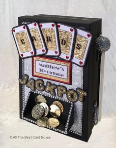 a black box with gold and silver playing cards in it that says happy birthday jackpot