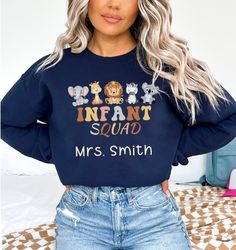 a woman with blonde hair wearing a navy sweatshirt that says infant squad, mrs smith