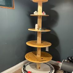 a tall wooden shelf sitting in the corner of a room next to a toy train