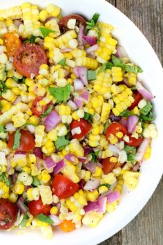 a white bowl filled with corn and tomatoes