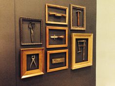 there are many framed pictures on the wall with scissors and other things in them,