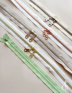 several different colored zippers are lined up on a white surface with one open and the other closed