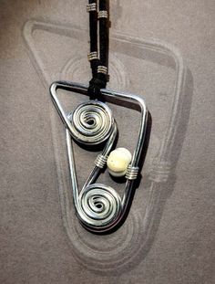 a pendant with two balls hanging from it's side on a cord that is attached to a string