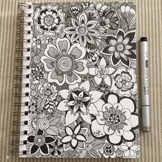 a coloring book with flowers on it and a marker pen next to the page that has been drawn