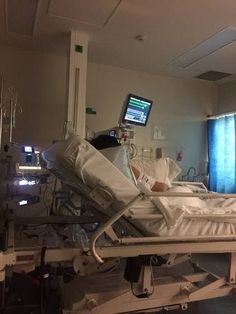 a hospital room with a monitor on the wall