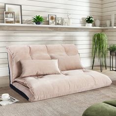 a living room with a futon sofa and coffee table on the floor next to it