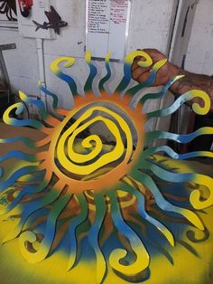 a man is working on an art project in his studio, with yellow and blue swirls