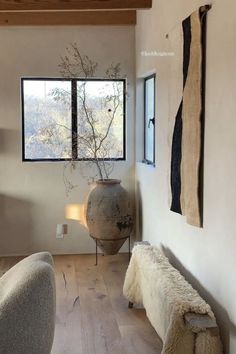 a large vase sitting next to a window in a living room