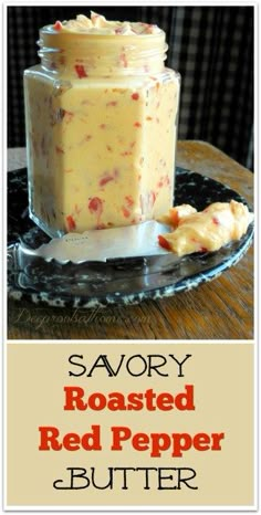 a glass jar filled with red pepper butter on top of a wooden table