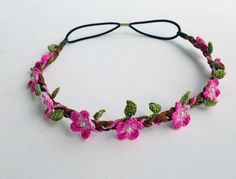 a headband with pink flowers and green leaves