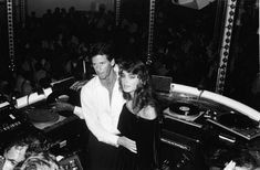 two people standing next to each other in front of dj's at a concert