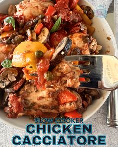 a white bowl filled with chicken and veggies next to a fork on top of a table