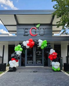 an entrance to a store with balloons in the shape of animals and letters on it