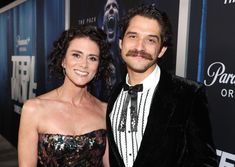 a man and woman standing next to each other on a red carpet