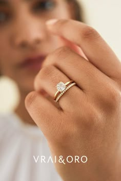 a woman wearing a diamond ring with her hand on her finger and the words vrai & oro written below it