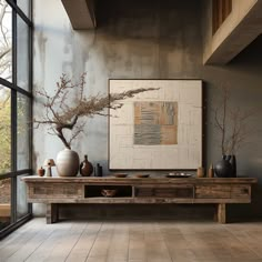 a table with some vases on top of it next to a window and a painting