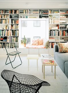 a living room filled with lots of bookshelves next to a couch and coffee table