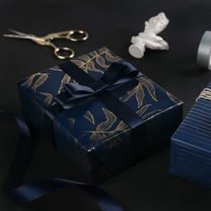 a blue gift box sitting on top of a table next to scissors