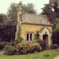 an old house with flowers growing around it