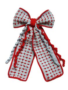 a crocheted bow with red and white trim