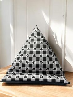 a black and white checkered blanket with paw prints on it sitting on top of a wooden table