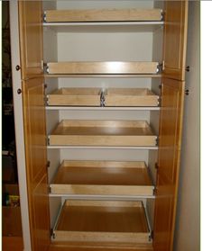 an empty closet with wooden shelves and drawers