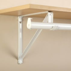 a white wall mounted shelf with two brackets on it