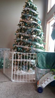 a baby crib next to a christmas tree