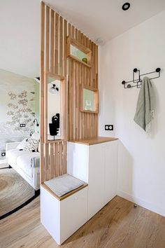 a white room with wood paneling on the wall and wooden stairs leading up to it