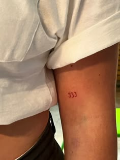 a woman with a small tattoo on her lower arm that reads 33 cents in cursive font